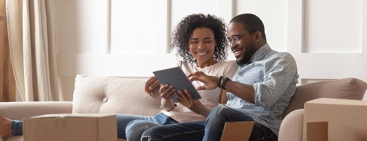 People on a couch looking at a tablet 