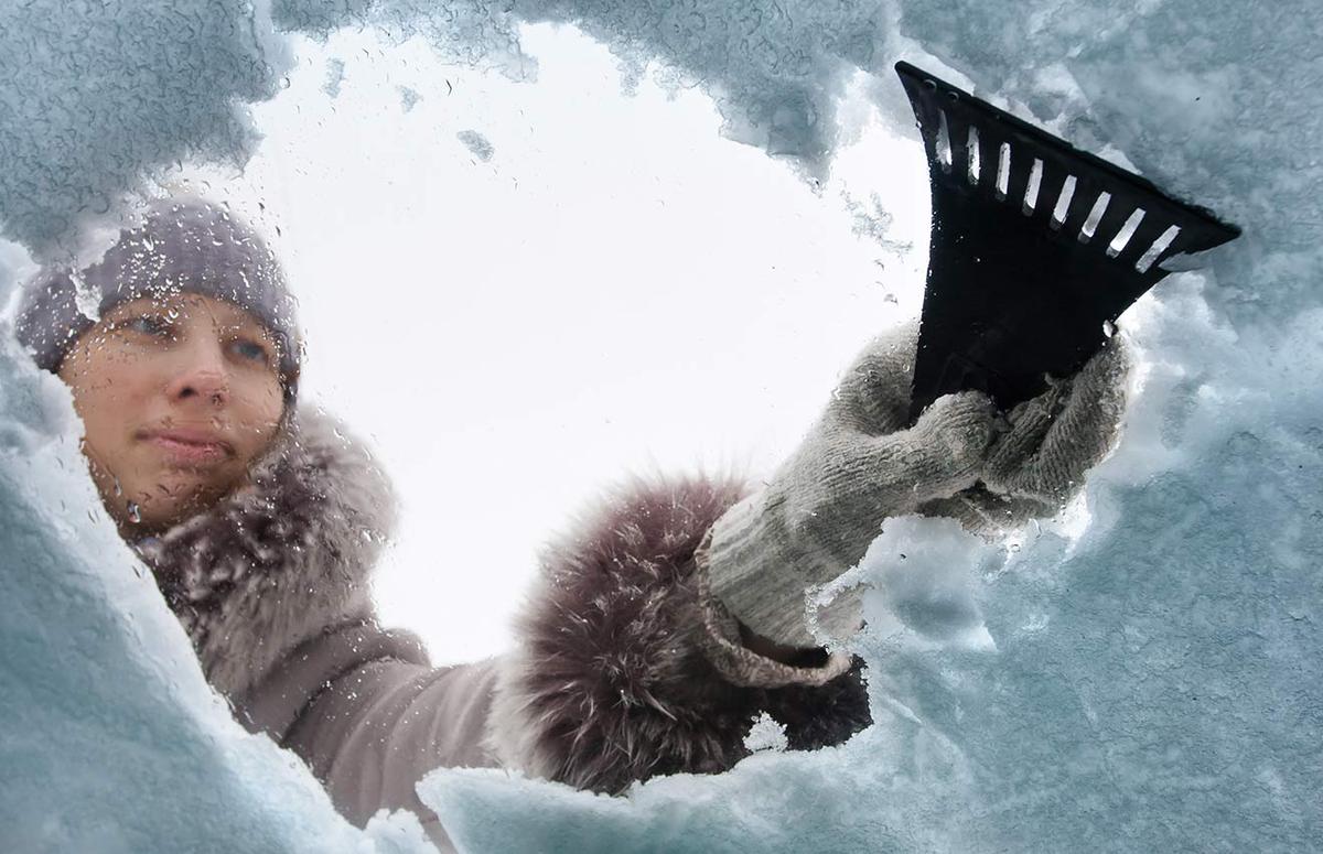 Person clearing the snow off their car. 