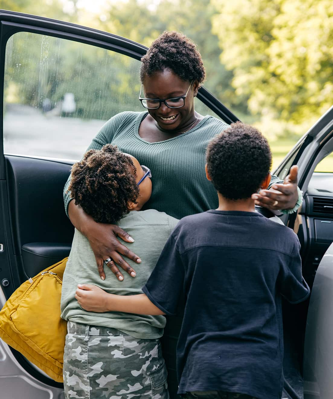 Young family hugs at the car