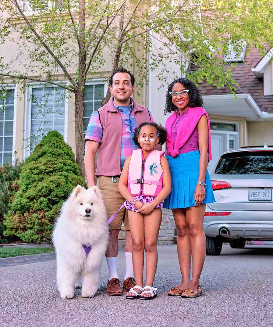 Family standing outside of their home with car