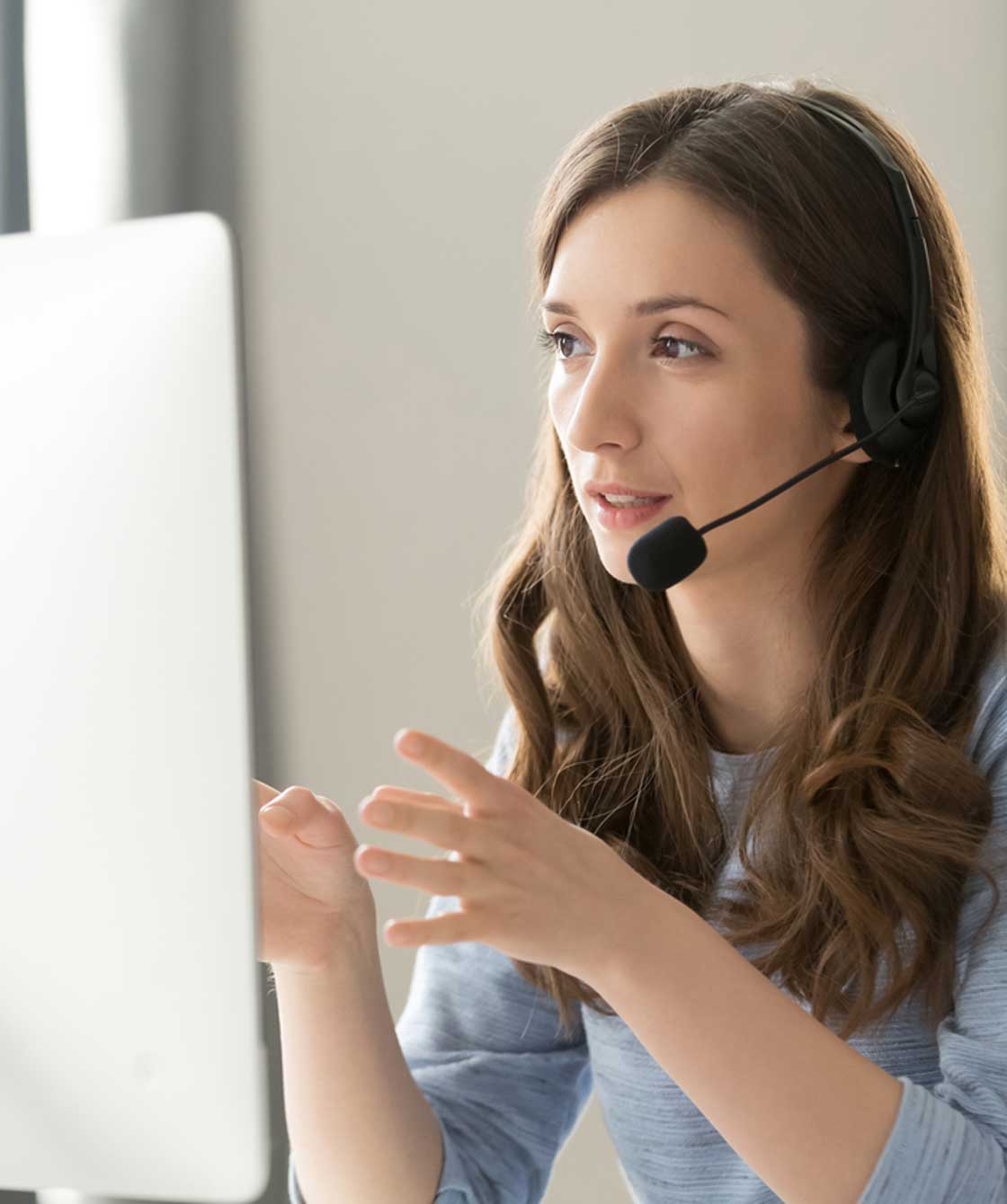 Customer service person talking on a headset while on a computer