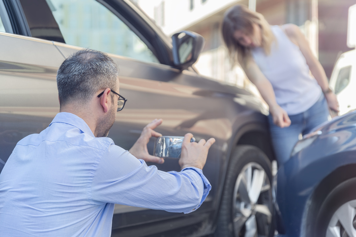 Man taking a photo after a car accident